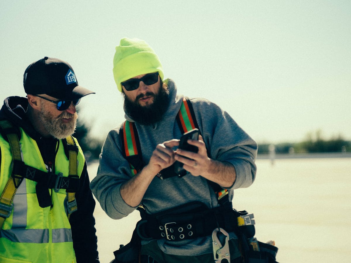 American Home Contractors' David Silverstein and Chuck Fistek review photos of a commercial roofing repair
