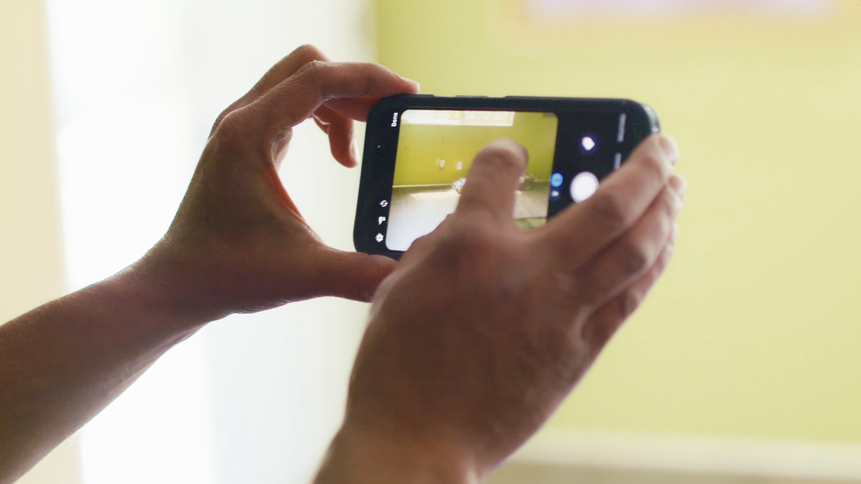 Contractor taking job site photo with a mobile phone to document construction progress in the field