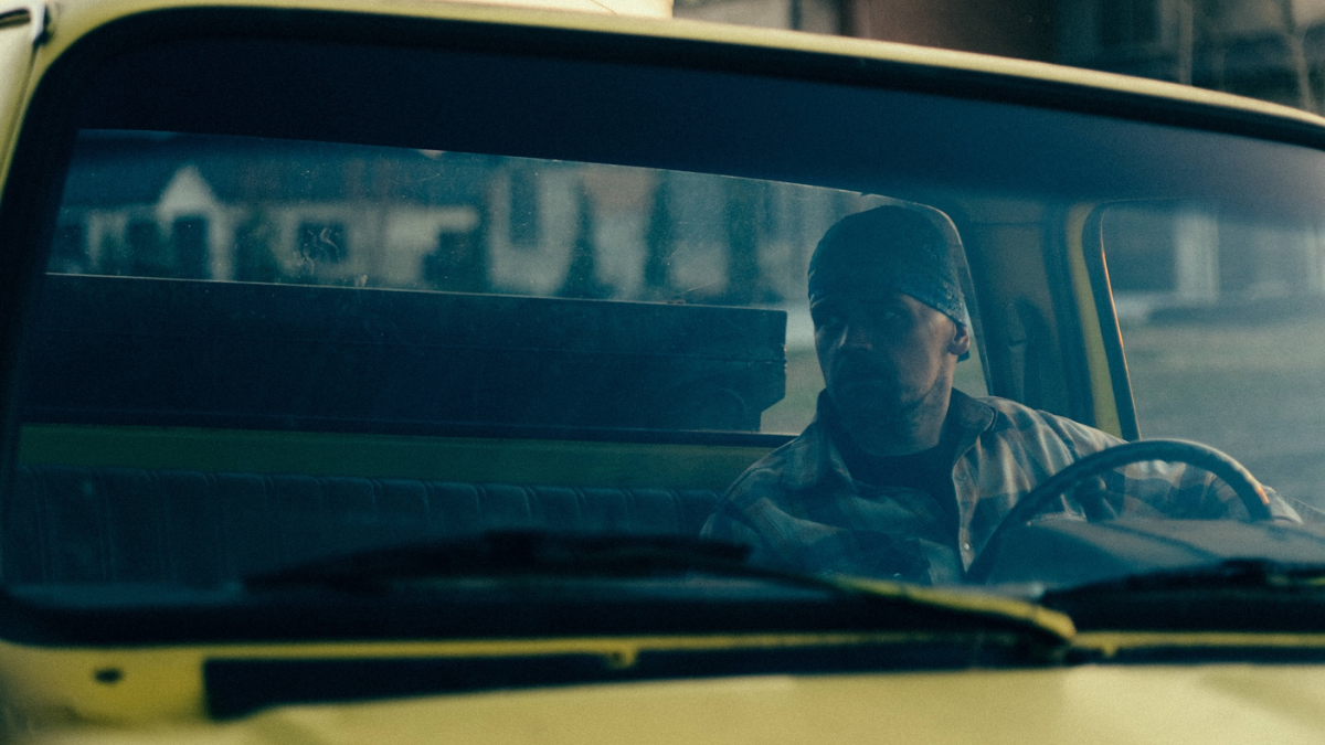 Contractor driving a work truck to a job site early in the morning.