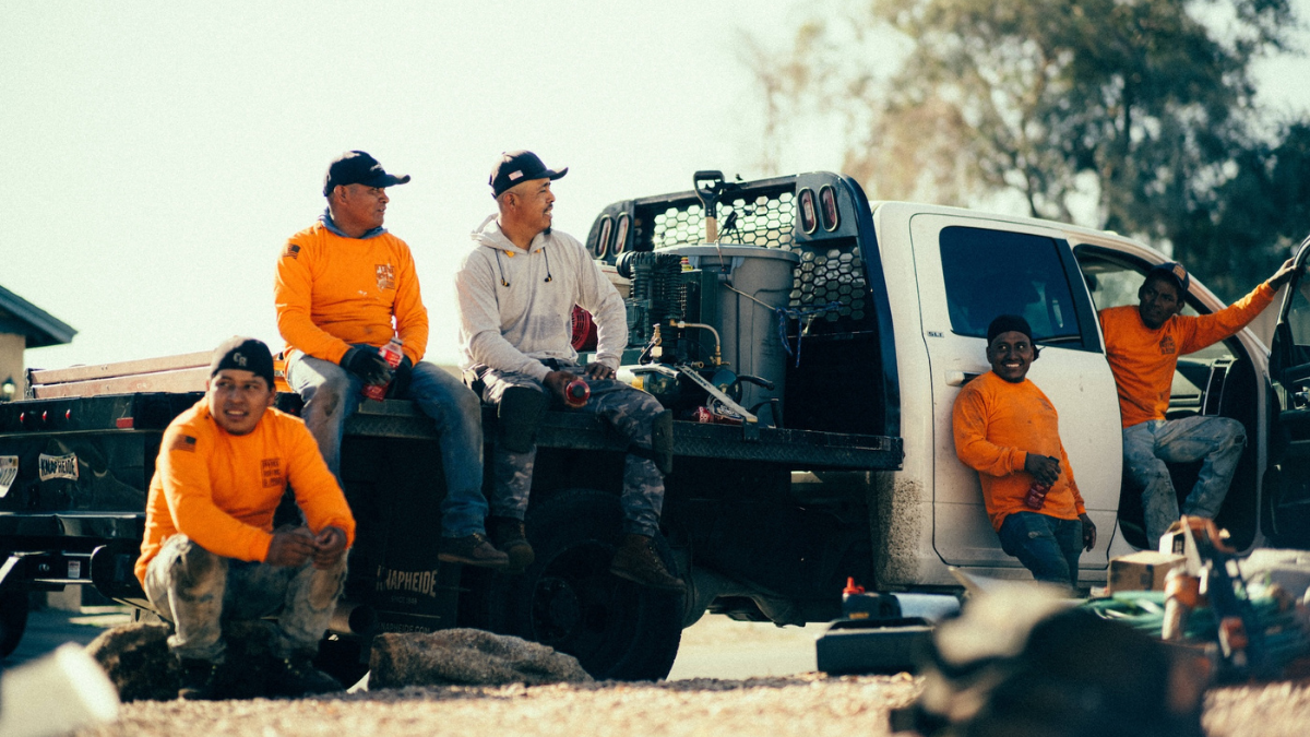 Crew of contractors takes a break at the truck on a job site
