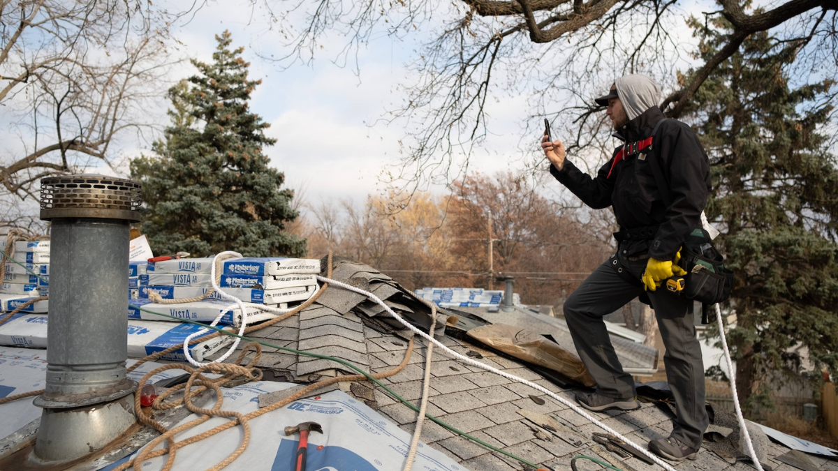 Contractor using mobile app to document roofing project.