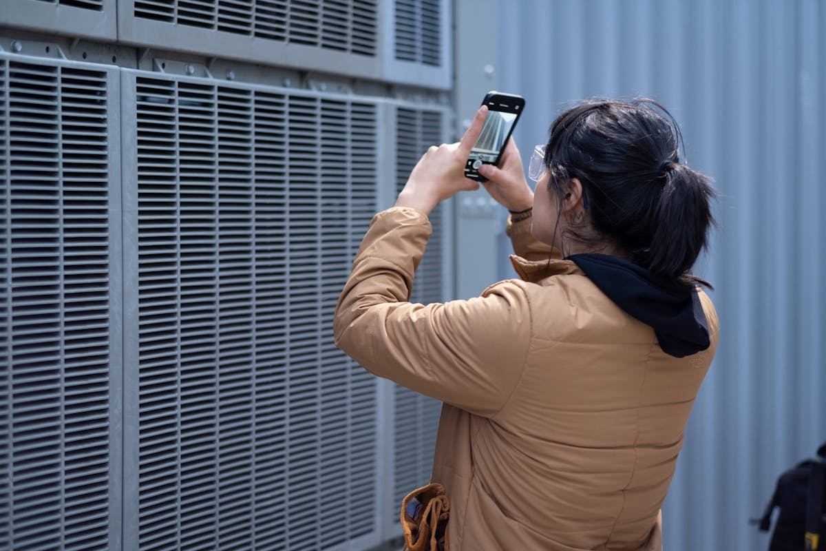 HVAC tech takes a photo of an industrial HVAC unit with their phone camera