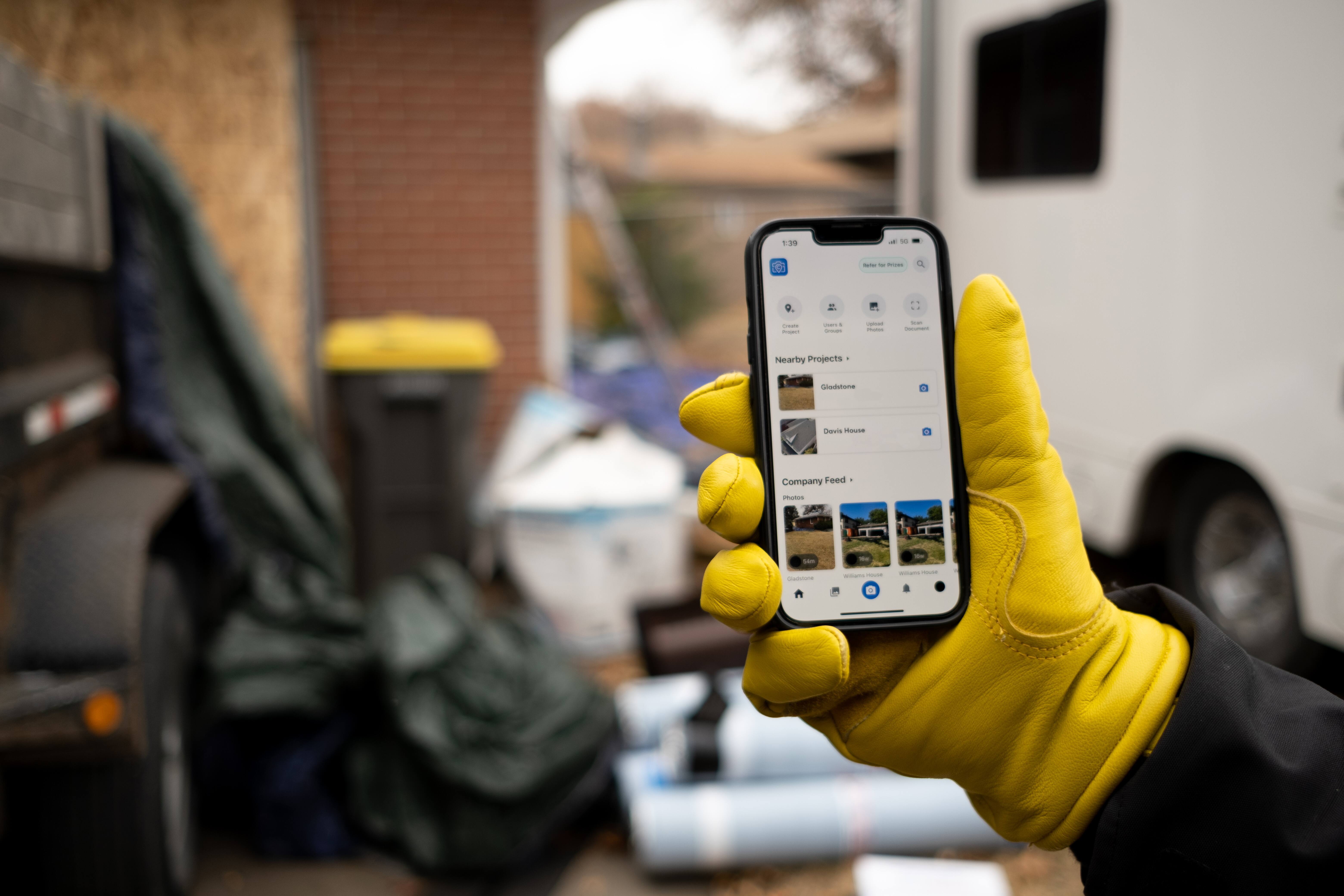 Field worker checks construction project details and job photos in mobile app.
