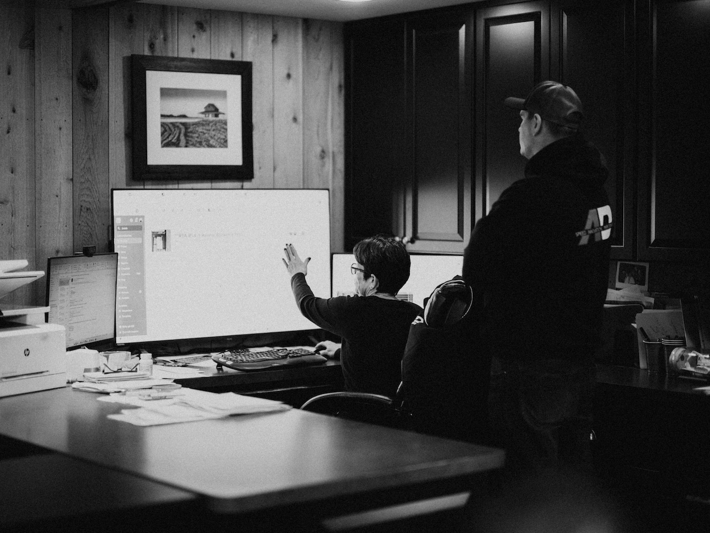 Team reviews construction project photos and documentation in office.