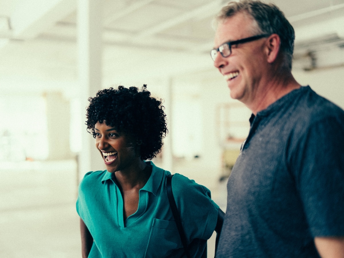 Project manager and contractor walk job site interior discussing renovation progress.