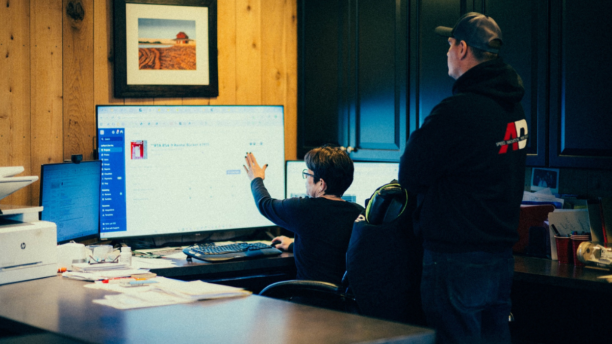 Contractor reviewing a business dashboard on a desktop computer in the office.