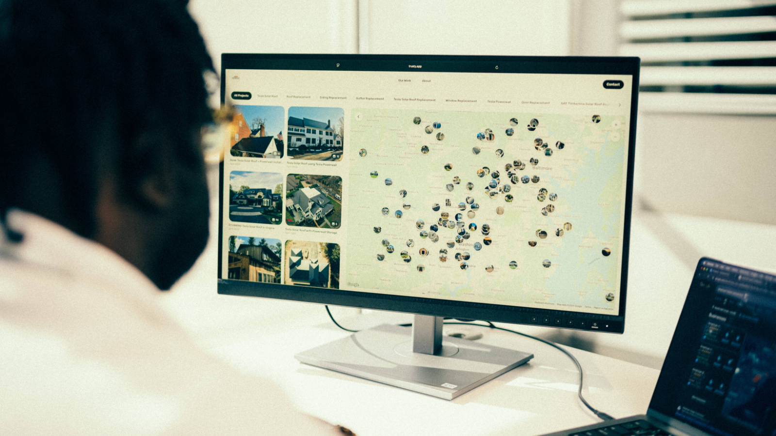 Contractor reviewing a CompanyCam project portfolio with a map view of completed roofing jobs across the Baltimore area.